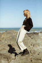 Load image into Gallery viewer, a sideview of a blonde female model wearing a black, crop, meg taljaard jersey
