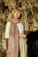 Load image into Gallery viewer, Blonde model wearing a Meg Taljaard pink scarf accessory against a rocky background 