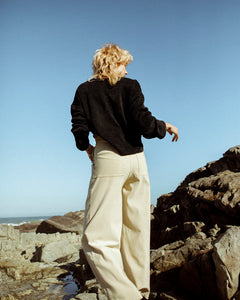 back view of a model wearing beige, high waisted trousers  